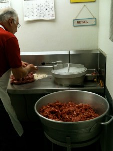 Making sausage by hand from a 50-pound drum. The Fiorellas make approximately 250 pounds daily. Trivarelli, TGG.