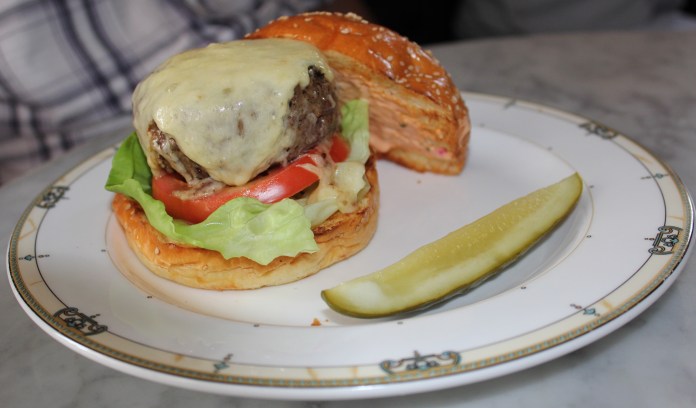 The Village Burger is an 8 oz patty served with fresh Boston bibb lettuce, tomato, and house-made Thousand Island dressing. The burger is served on a Pain au lait sesame roll. Trivarelli, TGG
